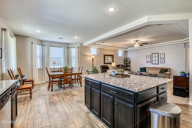kitchen with dark cabinetry, open floor plan, a ceiling fan, and recessed lighting