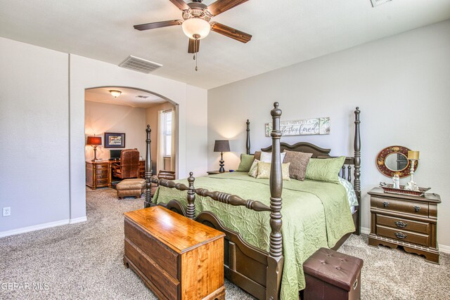 carpeted bedroom with arched walkways, baseboards, ceiling fan, and visible vents