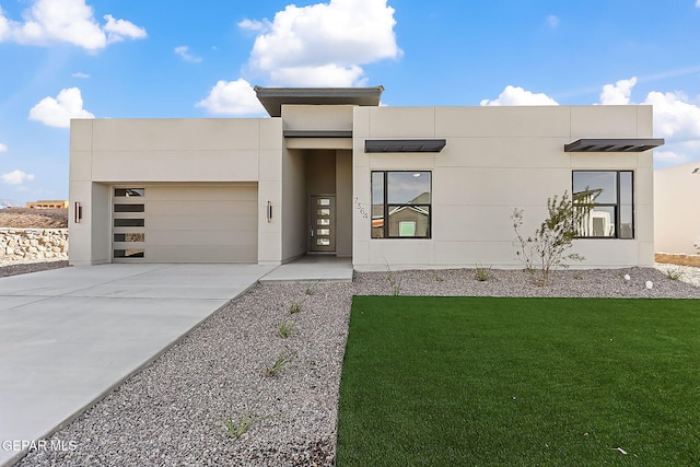 7364 Cimarron Rim Dr, El Paso, TX 79911 - contemporary house featuring concrete driveway, an attached garage, a front yard, and stucco siding