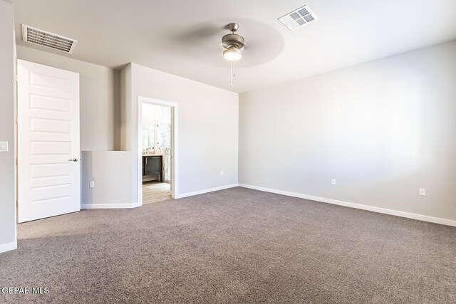 carpeted empty room featuring ceiling fan, visible vents, and baseboards