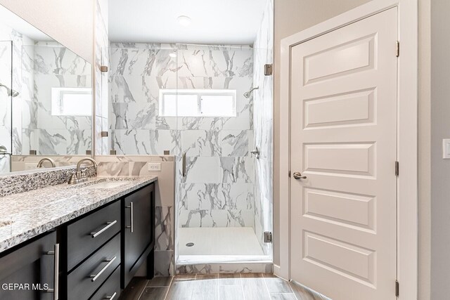 full bathroom featuring vanity and a marble finish shower