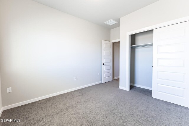 unfurnished bedroom featuring carpet flooring, baseboards, visible vents, and a closet