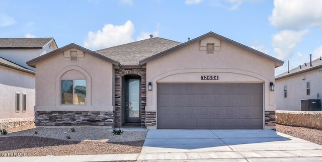 view of front of house featuring a garage, central AC unit, stucco siding, and stone siding