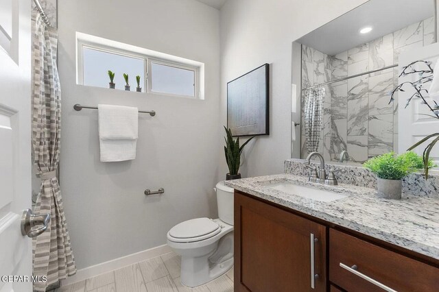 bathroom with vanity, baseboards, toilet, and curtained shower
