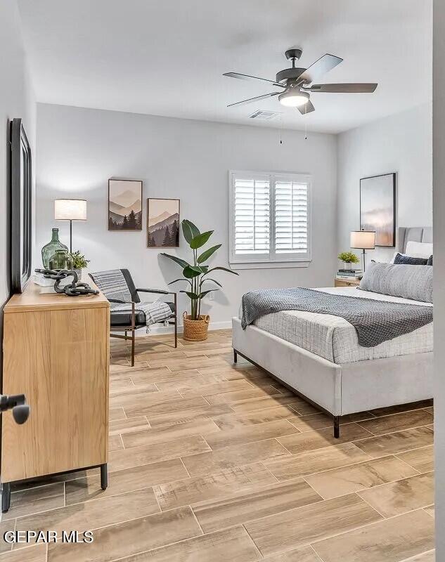 bedroom with baseboards, ceiling fan, light wood-style flooring, and visible vents