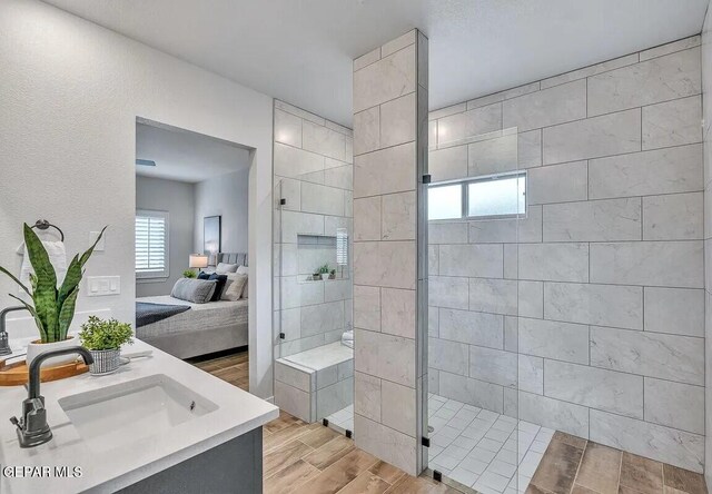 full bath with a walk in shower, a sink, ensuite bath, double vanity, and wood finished floors