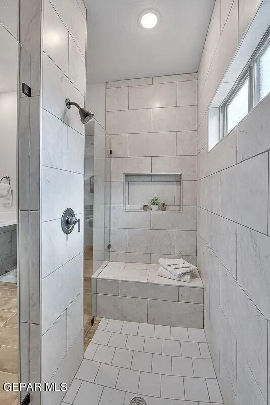 bathroom with tile patterned floors and tiled shower