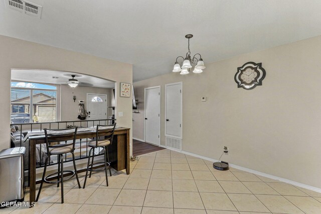 interior space featuring baseboards, ceiling fan with notable chandelier, and visible vents