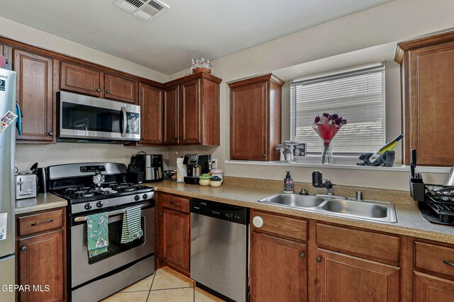 kitchen featuring visible vents, appliances with stainless steel finishes, a sink, light tile patterned floors, and light countertops