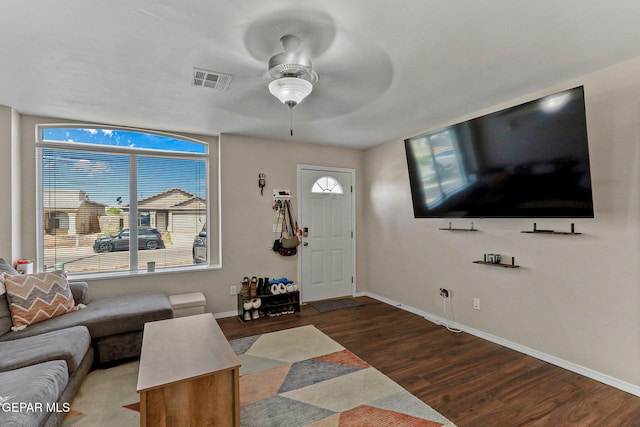 living area with visible vents, baseboards, ceiling fan, and wood finished floors