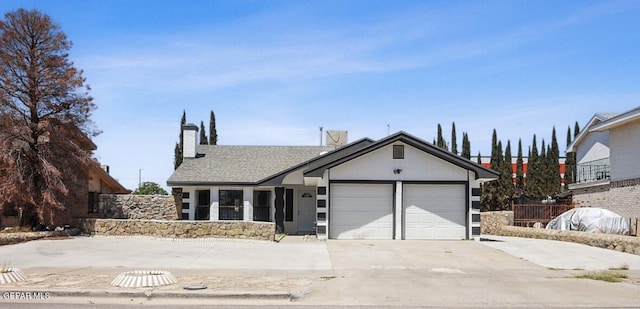 view of front of house featuring an attached garage, driveway, and a chimney