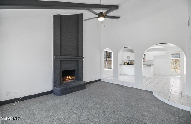 unfurnished living room featuring carpet flooring, ceiling fan, and a healthy amount of sunlight