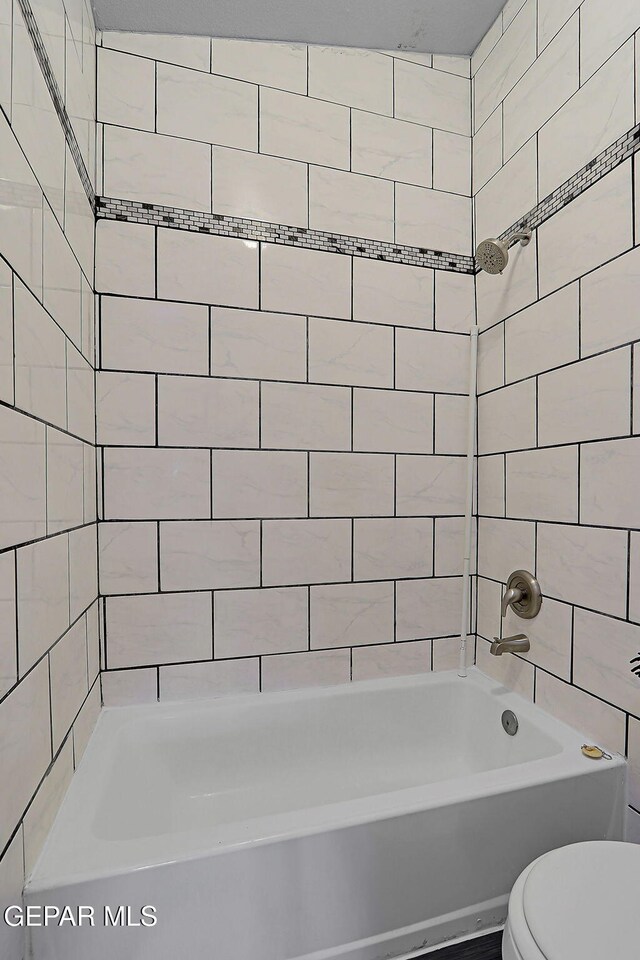 bathroom featuring bathtub / shower combination and toilet