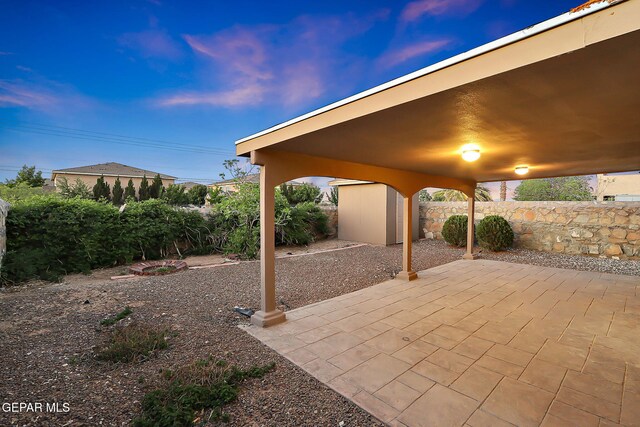 view of patio / terrace featuring a storage unit, an outdoor structure, and fence