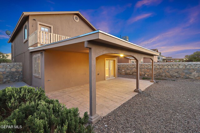 view of home's exterior with a patio area, stucco siding, and fence