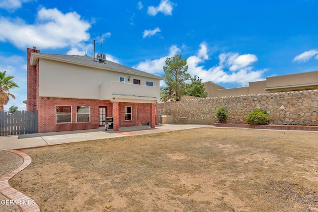 12541 Setting Sun Dr, El Paso, TX 79938 - rear view of house featuring a fenced backyard, stucco siding, a chimney, brick siding, and a patio area