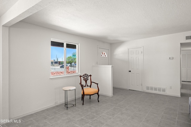 5540 Norwood Ct, El Paso, TX 79924 - sitting room featuring a textured ceiling, tile patterned flooring, and baseboards