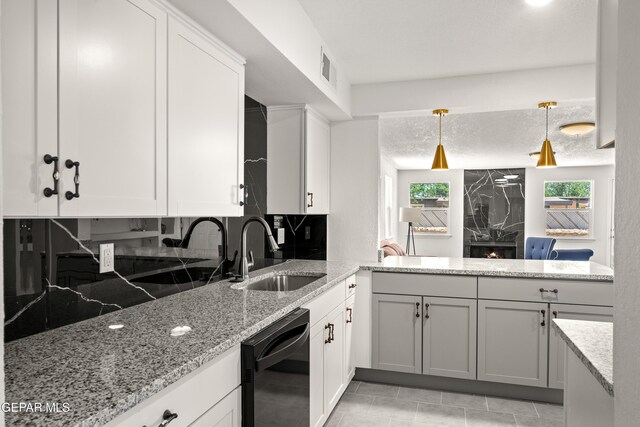 5540 Norwood Ct, El Paso, TX 79924 - kitchen with black dishwasher, a sink, a peninsula, light stone counters, and backsplash