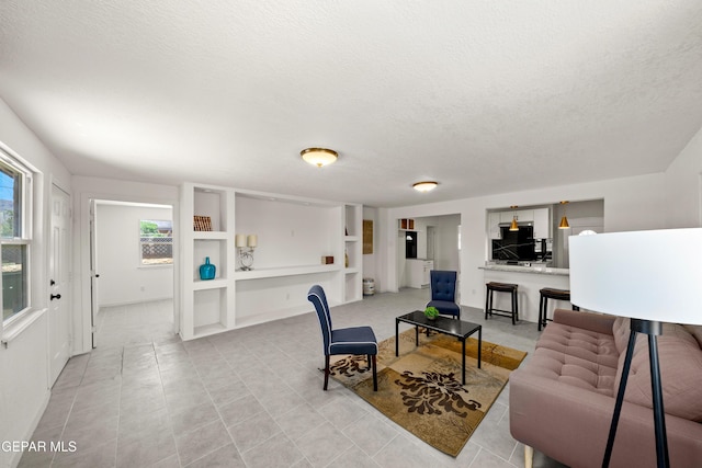 5540 Norwood Ct, El Paso, TX 79924 - living room featuring a textured ceiling, built in shelves, and light tile patterned floors