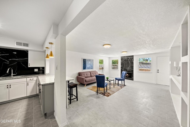 5540 Norwood Ct, El Paso, TX 79924 - living room with a textured ceiling, light tile patterned flooring, and a premium fireplace
