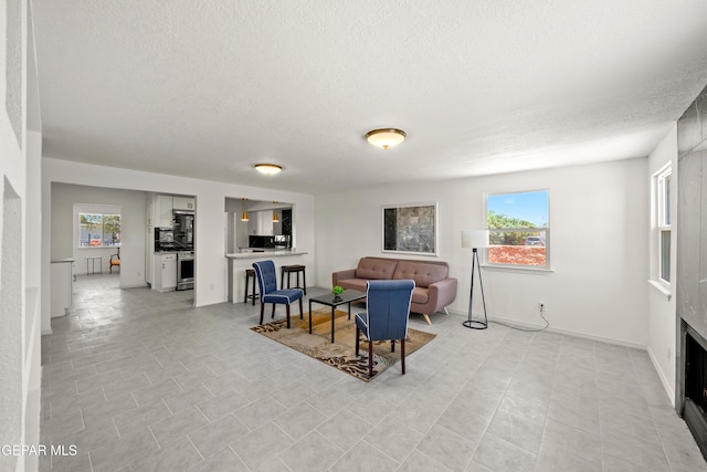 5540 Norwood Ct, El Paso, TX 79924 - living room with a textured ceiling, healthy amount of natural light, and baseboards