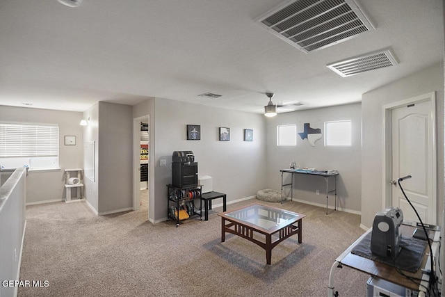 living room featuring plenty of natural light, a ceiling fan, and visible vents