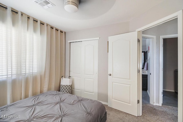 bedroom with carpet flooring, visible vents, and a closet