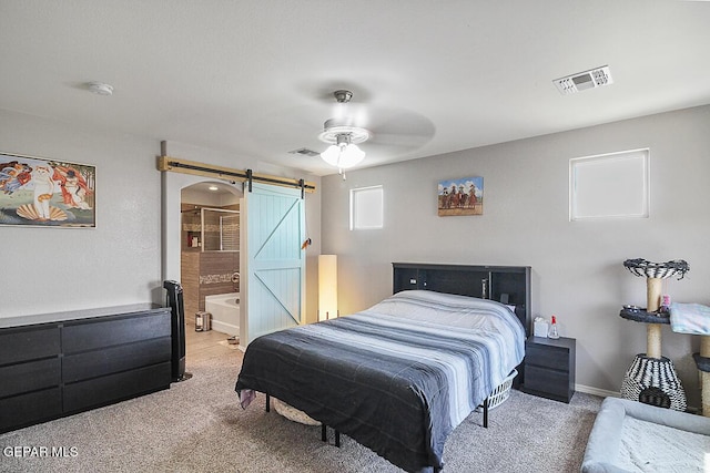 bedroom with carpet flooring, visible vents, and a barn door
