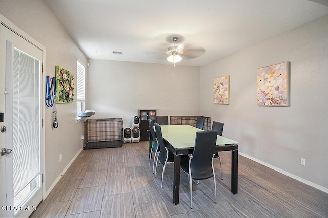 dining area featuring a ceiling fan, baseboards, visible vents, and wood finished floors