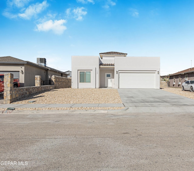 modern home with a tile roof, cooling unit, concrete driveway, an attached garage, and stucco siding