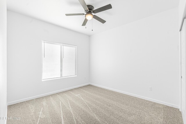 unfurnished room featuring baseboards, carpet, and a ceiling fan