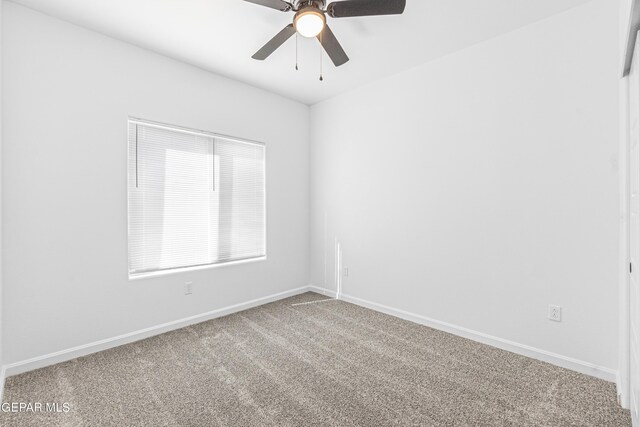 carpeted spare room with baseboards and ceiling fan