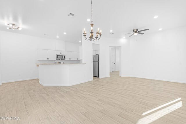 unfurnished living room featuring light wood-style flooring, ceiling fan with notable chandelier, recessed lighting, baseboards, and visible vents