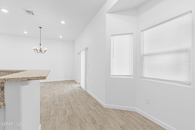 unfurnished dining area with visible vents, baseboards, recessed lighting, a chandelier, and light wood finished floors