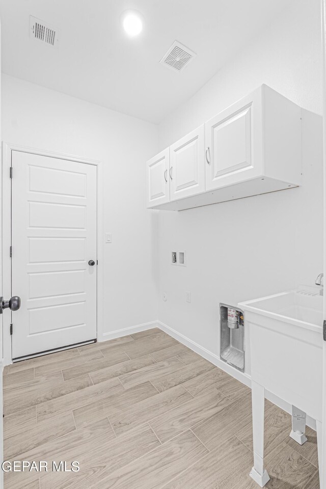 clothes washing area featuring visible vents, hookup for a washing machine, cabinet space, and baseboards