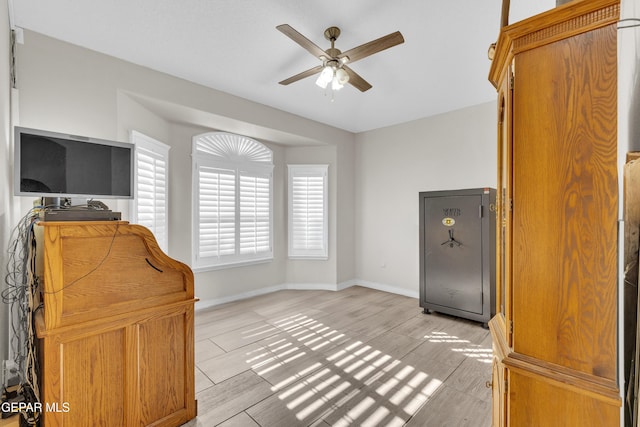 office area featuring baseboards, ceiling fan, and light wood-style flooring
