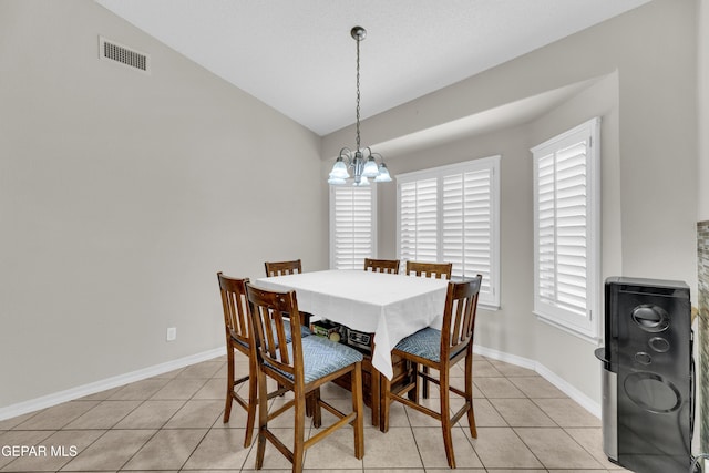 dining space with light tile patterned floors, plenty of natural light, a chandelier, and visible vents