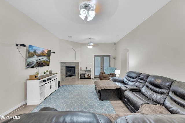 living area featuring visible vents, a fireplace, ceiling fan, french doors, and arched walkways