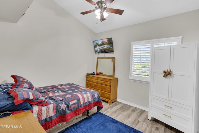bedroom with baseboards, a ceiling fan, light wood-style flooring, and lofted ceiling