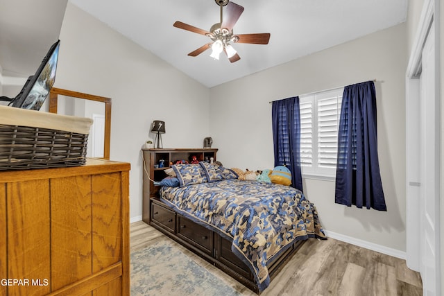 bedroom with a ceiling fan, baseboards, wood finished floors, and lofted ceiling