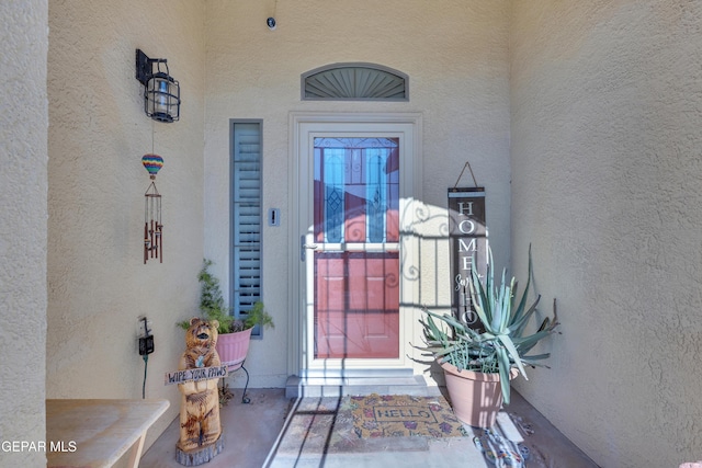 entrance to property featuring stucco siding