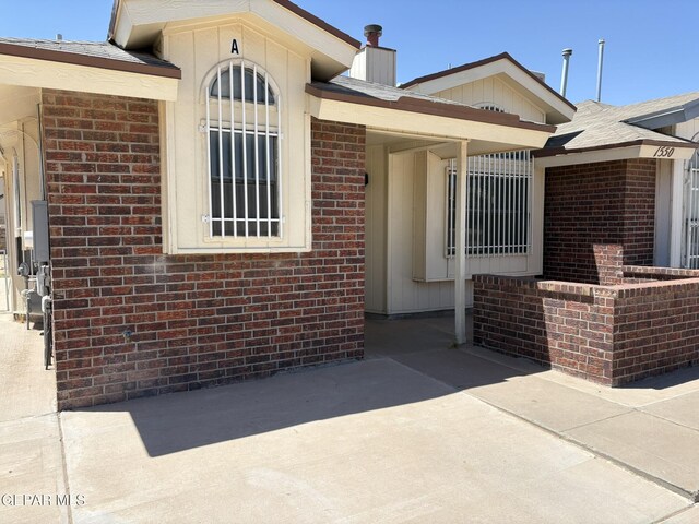 doorway to property featuring brick siding