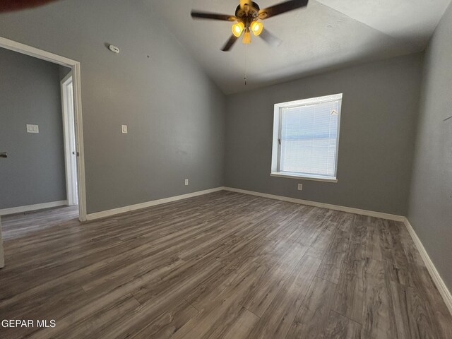 empty room with baseboards, dark wood finished floors, ceiling fan, and lofted ceiling