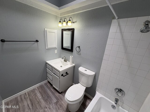 bathroom with vanity, wood finished floors, toilet, baseboards, and bathtub / shower combination