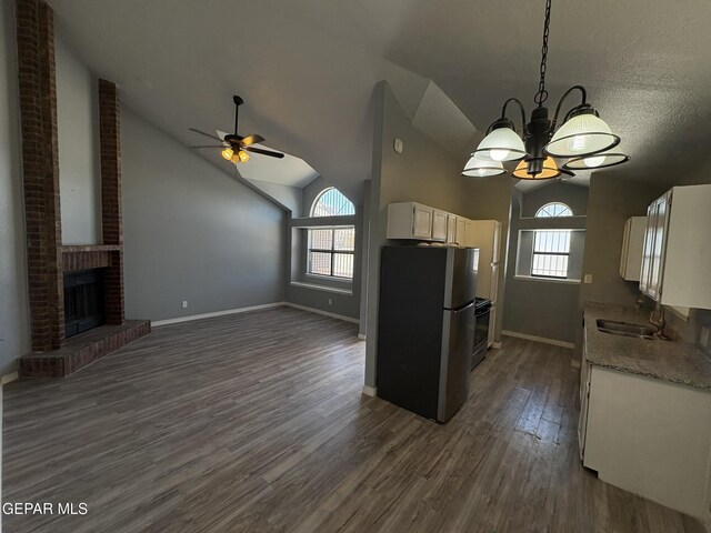 kitchen with freestanding refrigerator, a sink, vaulted ceiling, and a healthy amount of sunlight