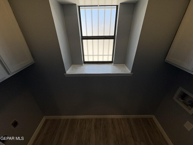 interior space with laundry area, baseboards, washer hookup, and wood finished floors