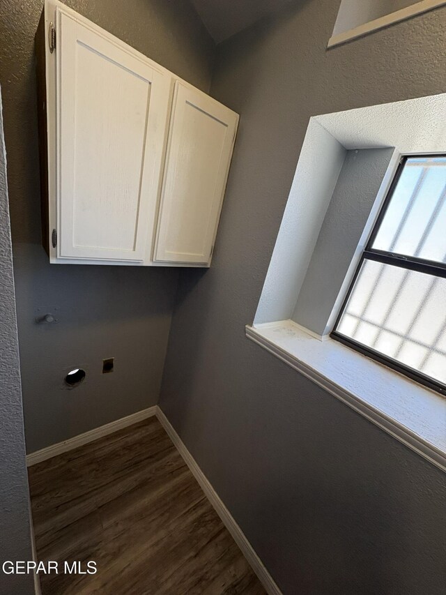 laundry area with cabinet space, electric dryer hookup, dark wood-style floors, and baseboards