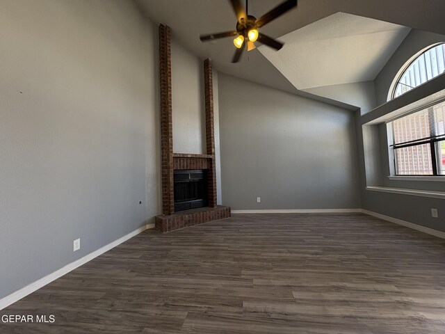 unfurnished living room with ceiling fan, a brick fireplace, high vaulted ceiling, baseboards, and dark wood-type flooring