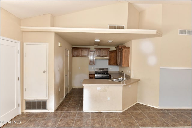kitchen with a sink, lofted ceiling, stainless steel gas range oven, and visible vents