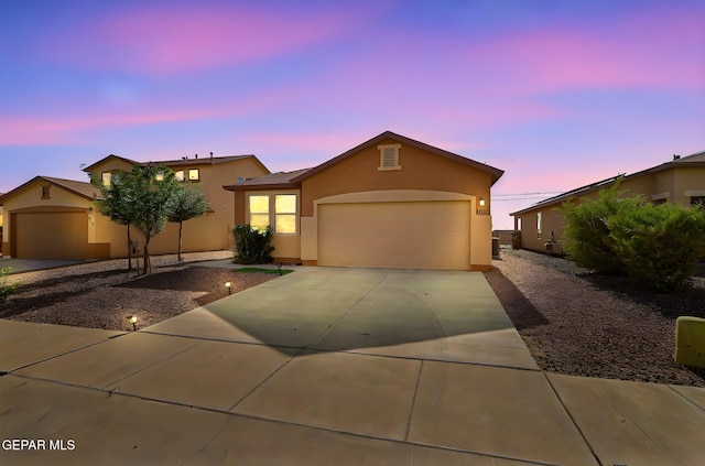 1021 Aerodyne Pl, El Paso, TX 79928 - view of front of home featuring stucco siding, an attached garage, and driveway